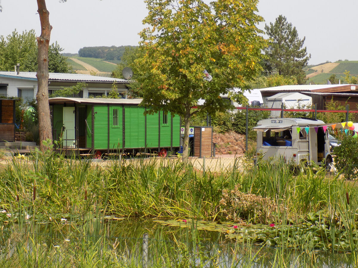 Campingpark Lindelgrund mit begrünten Terrassen und historischem Waggon